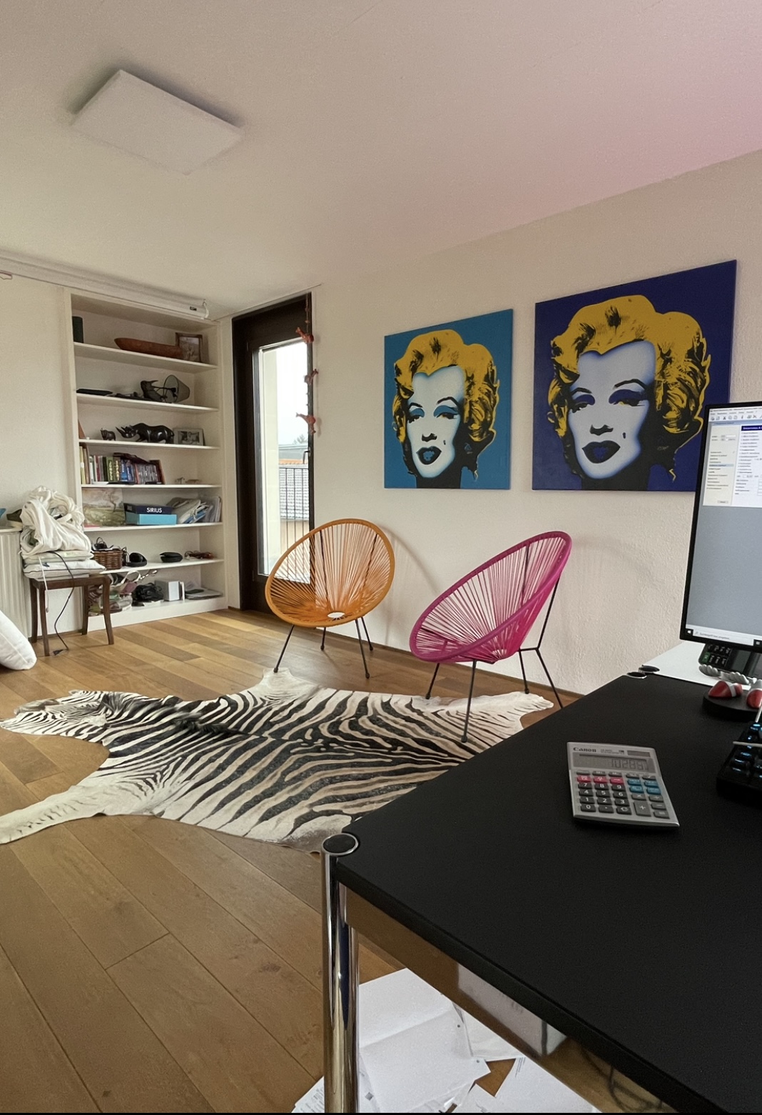 Zwei Pop-Art-Bilder an der Wand über dem Arbeitsplatz aufgehängt